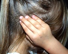 Child closing face with hands